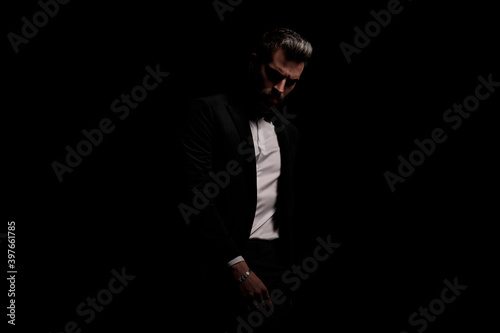 mysterious businessman in black velvet tuxedo posing