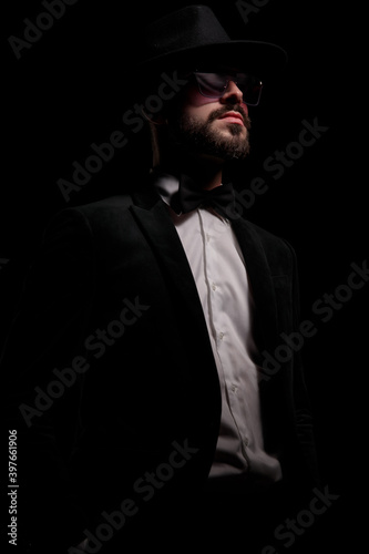 cool elegant guy in black velvet tuxedo looking up