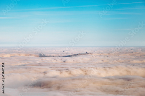 bird eye view at clouds in blue sky top view from drone from airplane window