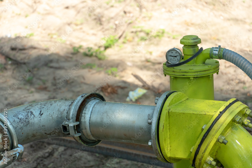 drainage system for pumping out groundwater out of the ground. Water pumping station. A large yellow water pipe with a pressure gauge. drainage system for pumping out groundwater out of the ground. Water pumping station. A large yellow water pipe with a pressure gauge.