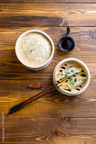 chinese dumplings in wooden steamer with chopsticks soy sauce Chinese Traditional cuisine concept Overhead.