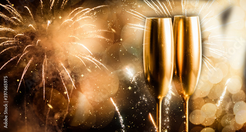 golden champagne glasses and fireworks at new year