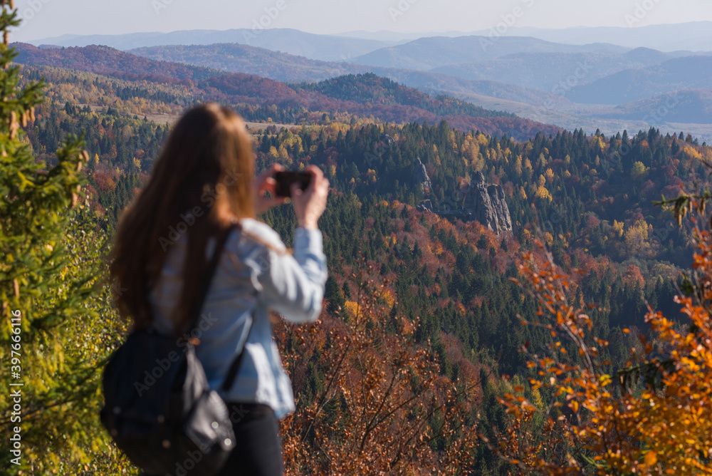 Tourist photographs a Tustan, rocks and fortress in Carpathian mountains