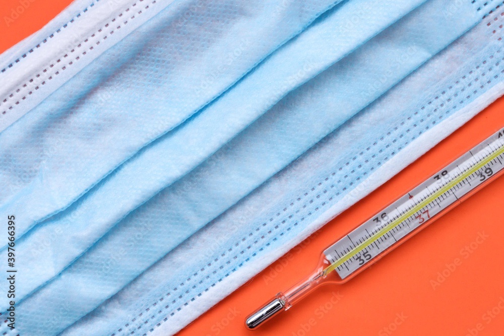 Medical mask and mercury thermometer close up Medical mask and mercury thermometer close up