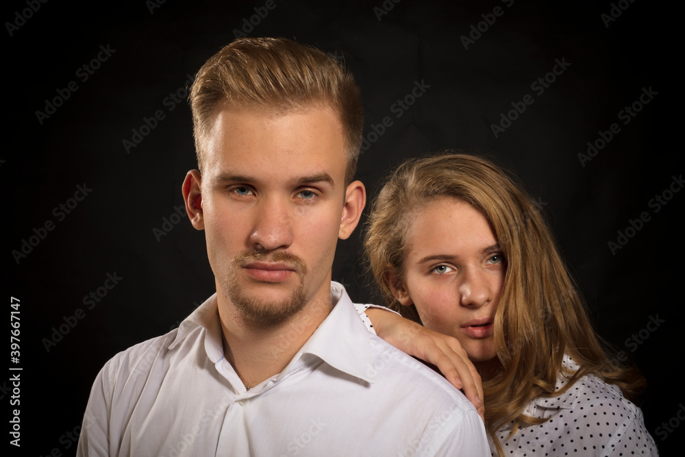 Young beautiful couple studio portrait on black background. Young beautiful couple studio portrait on black background.
