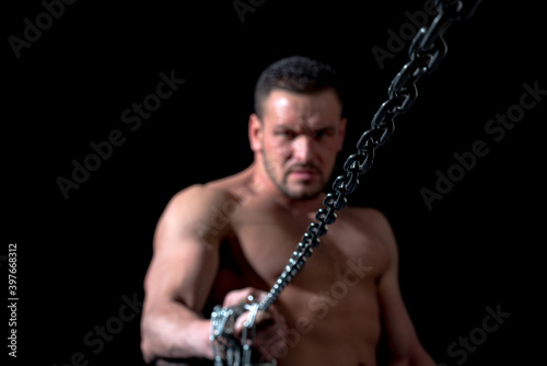 Man with chain. Concept of broken metal chains. Strong one with perfect muscles. Mans power.