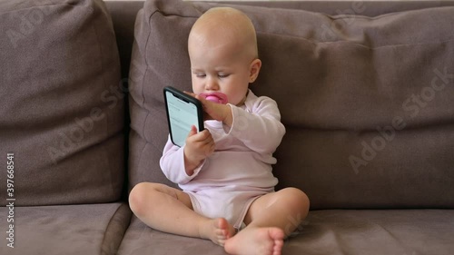 Infant play with smartphone and sitting on sofa