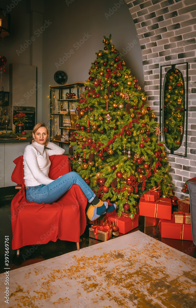 Young woman close up under the festive fir-tree indoors with the boxes of gifts.Christmas photo Young woman close up under the festive fir-tree indoors with the boxes of gifts.Christmas photo