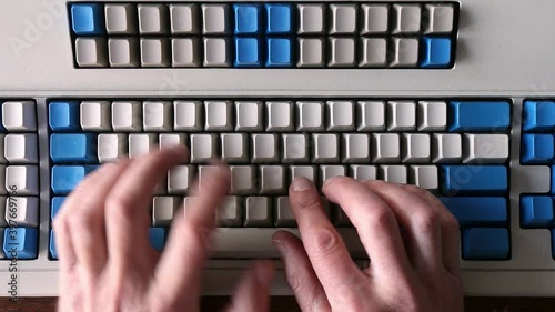 Touch typing on a vintage clicky keyboard with blank keys without letters. Every key press is marked with an audible click sound due to old buckling spring design. Fingers on both hands busy at work.