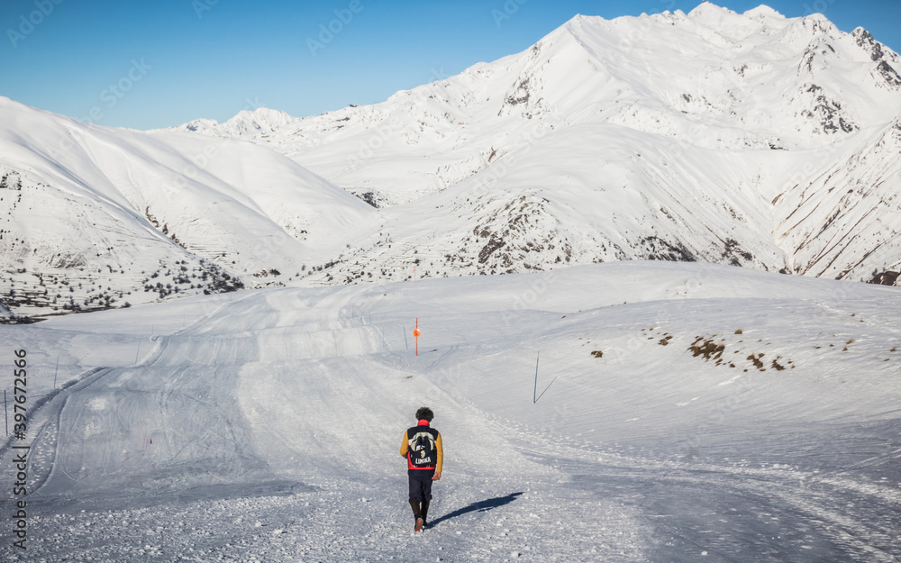 Pistes de ski vide dans la station des Deux-alpes en hiver devant des sommets enneigés