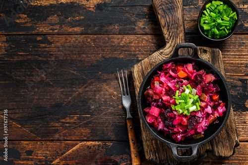Russian beetroot vegetable salad vinaigrette in a pan. Wooden background. Top view. Copy space