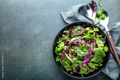 Salad bowl, healthy food. Fresh salad mix of baby spinach, arugula leaves, basil, chard and lambs lettuce.