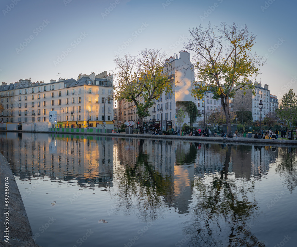 Paris, France - 12 28 2019: Reflections of buildings at the Canal Saint-Martin at sunset