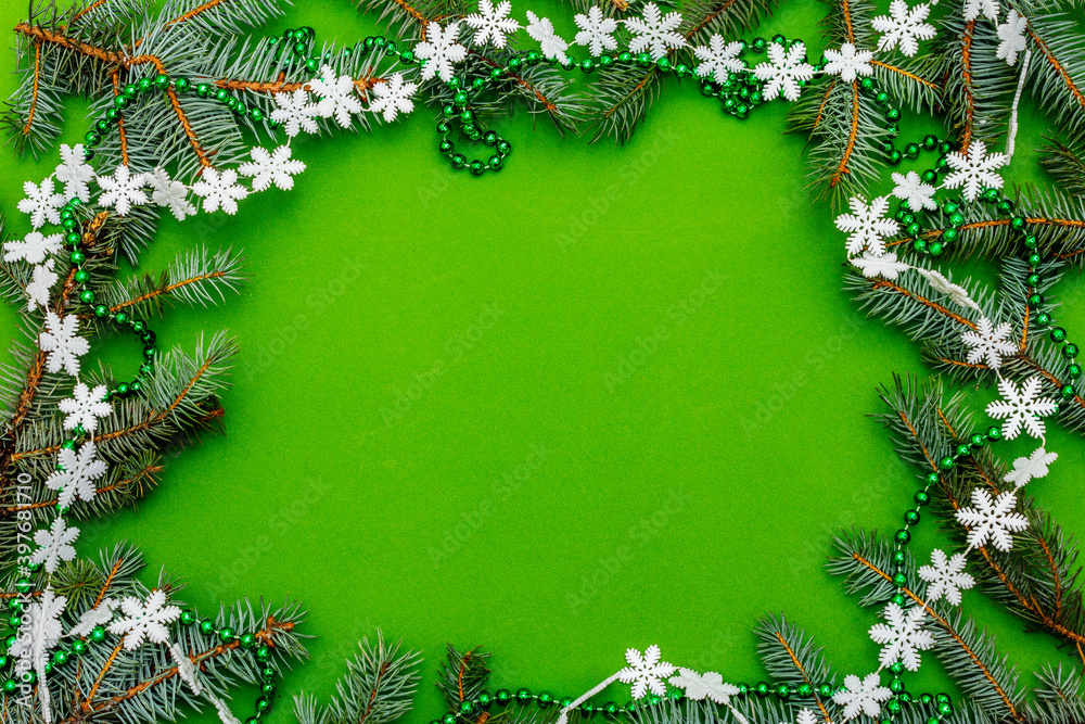 Christmas background with fresh Xmas tree branches and New Year decor on green background