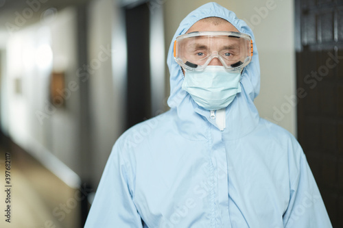 Worker making sanitizing while wearing hazmat suit
