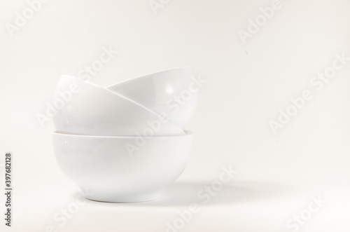 stack of white bowls on a white background. Minimalistic, stylish, trendy concept. tinted. with place for text