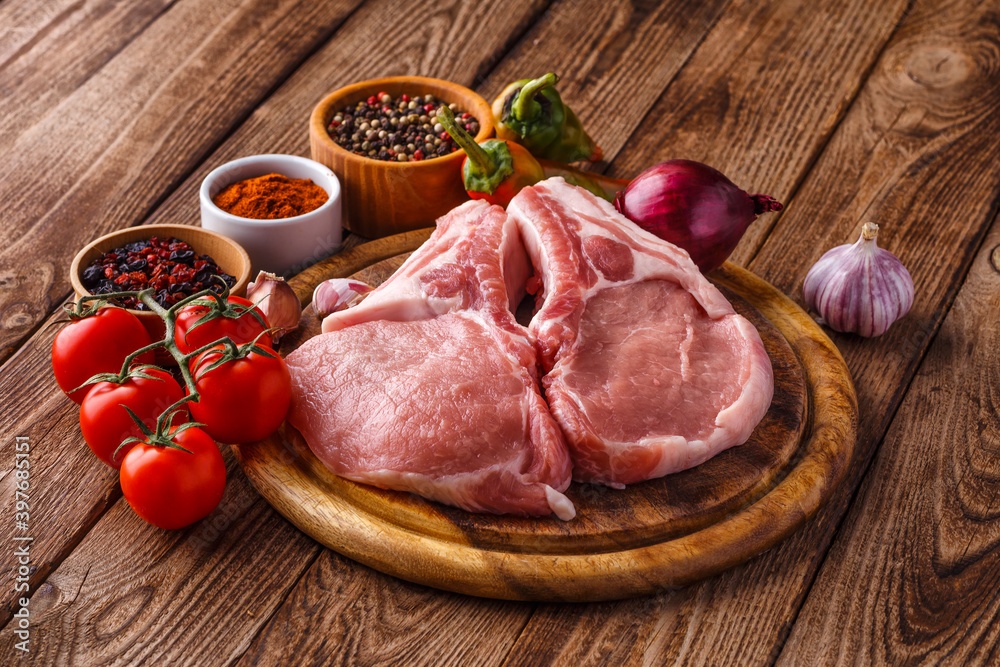 fresh raw new-york steak on wooden Board on wooden background with salt and pepper in a rustic style. fresh raw new-york steak on wooden Board on wooden background with salt and pepper in a rustic style.