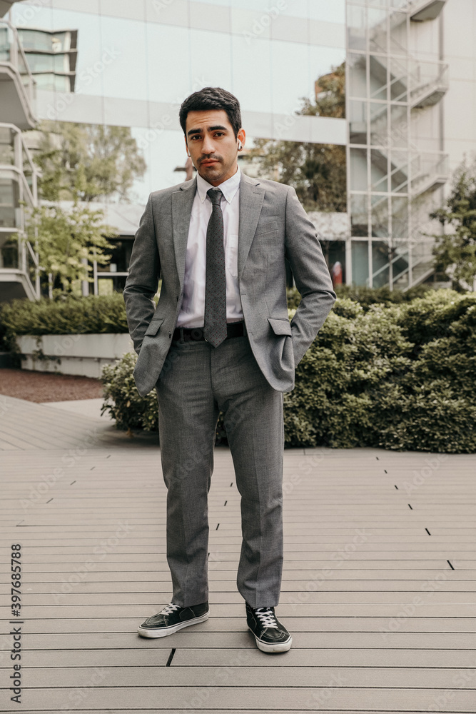 Vertical portrait of confident and successful young businessman. Outdoor.