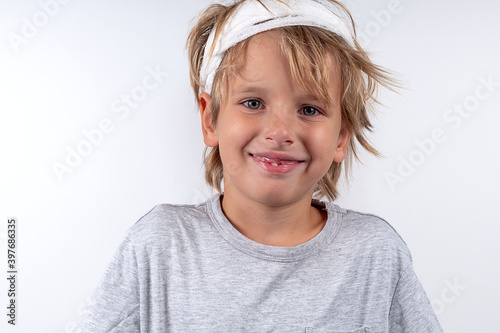 Portrait young caucasian cute boy blond hair with trauma injury and bandage head. Isolated on white background. Fun smile emotions.