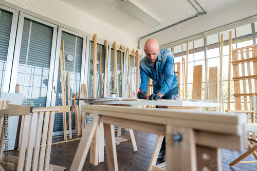 Caucasian carpenter preparing wooden furniture for customers showing handicraft carpentry concept