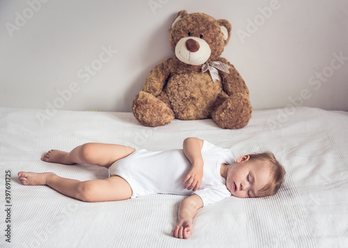 Baby sleepin with teddy bear.  photo