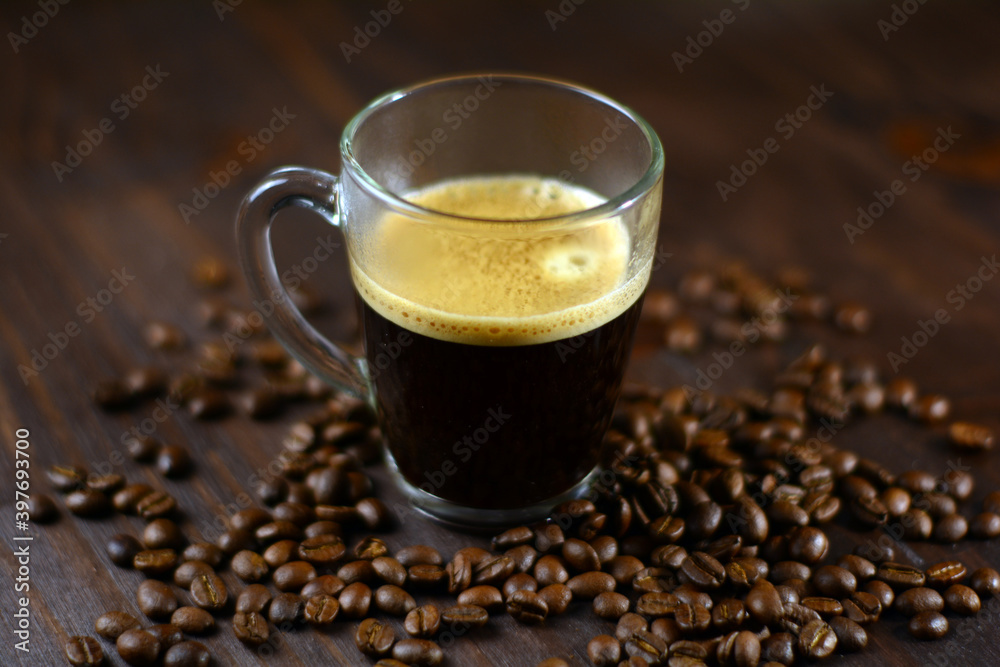 Cup of espresso and coffee beans on a wooden table Cup of espresso and coffee beans on a wooden table