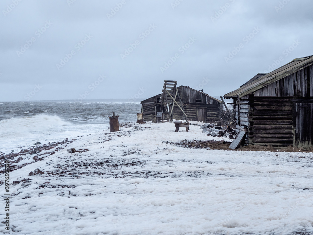 Dramatic seascape with a raging White sea and a fishing hut on the shore. Kandalaksha bay. Umba. Russia Dramatic seascape with a raging White sea and a fishing hut on the shore. Kandalaksha bay. Umba. Russia