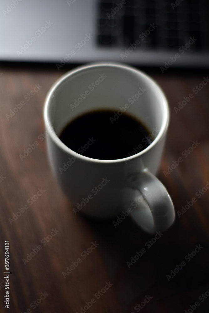 Cup of coffee and notebook on a wooden office table Cup of coffee and notebook on a wooden office table