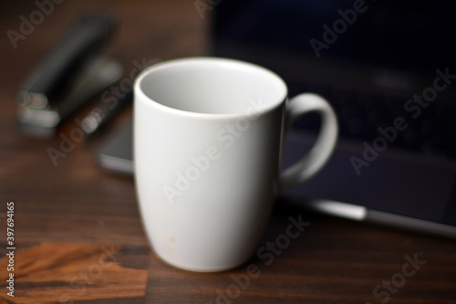 Cup of coffee and notebook on a wooden office table