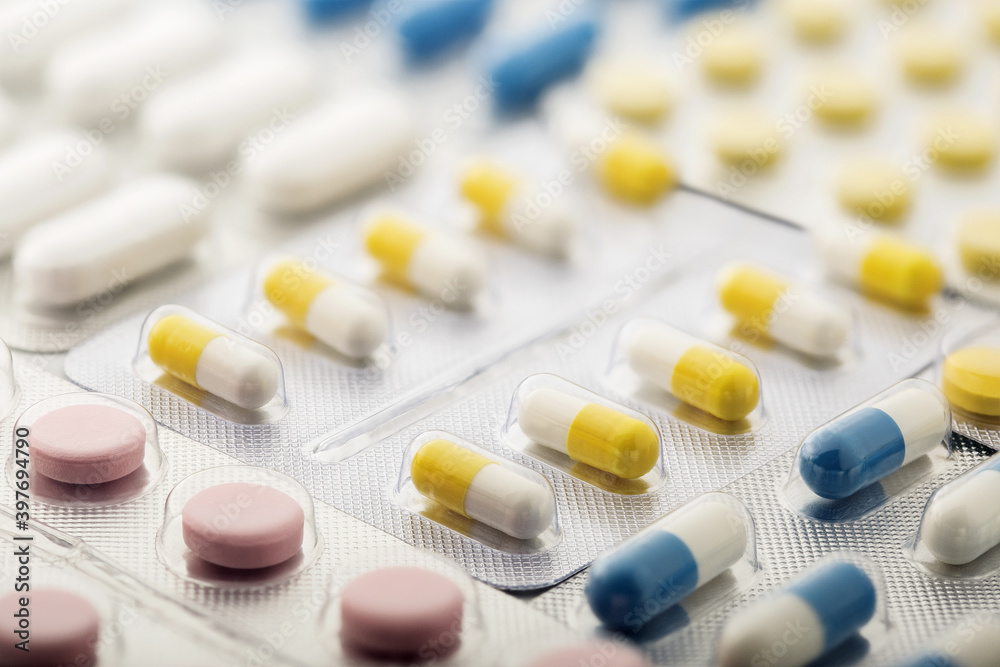 Heap of medical pills in white and other colors. Pills in plastic package. Concept of healthcare and medicine. Heap of medical pills in white and other colors. Pills in plastic package. Concept of healthcare and medicine.