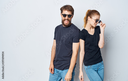 cheerful young couple wearing sunglasses casual wear studio communication isolated background