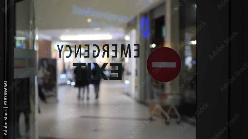 Emergency exit sign on empty city mall during pandemic Emergency exit sign on empty city mall during pandemic