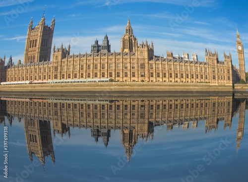 Houses of Parliament reflected in river Thames in London with fi