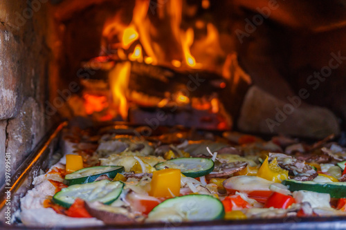 Pizza baking in an open handmade firewood oven