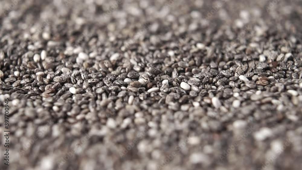 Falling chia seeds close-up with rotation. Macro shot. Slow motion Falling chia seeds close-up with rotation. Macro shot. Slow motion
