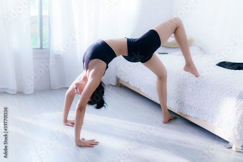 Young Asian woman practice yoga in bedroom in the morning