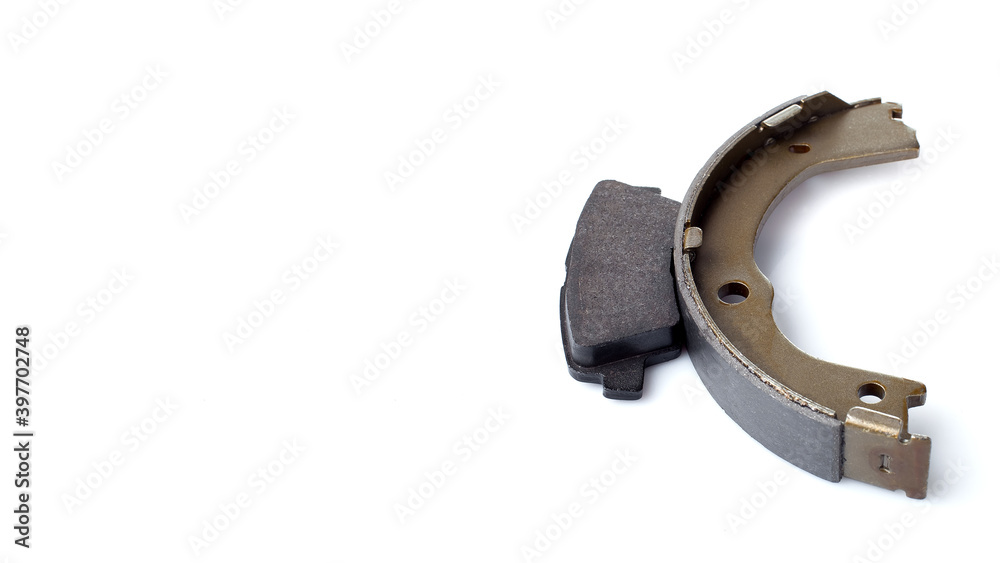 set of asbestos brake pads and brake shoe for disc and drum brakes, replacement spare parts of the car brake system isolated on white background with copy space banner, nobody. set of asbestos brake pads and brake shoe for disc and drum brakes, replacement spare parts of the car brake system isolated on white background with copy space banner, nobody.