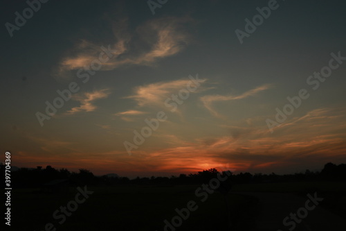 The orange light of sunrise, clouds , blue sky and silhouette in the morning