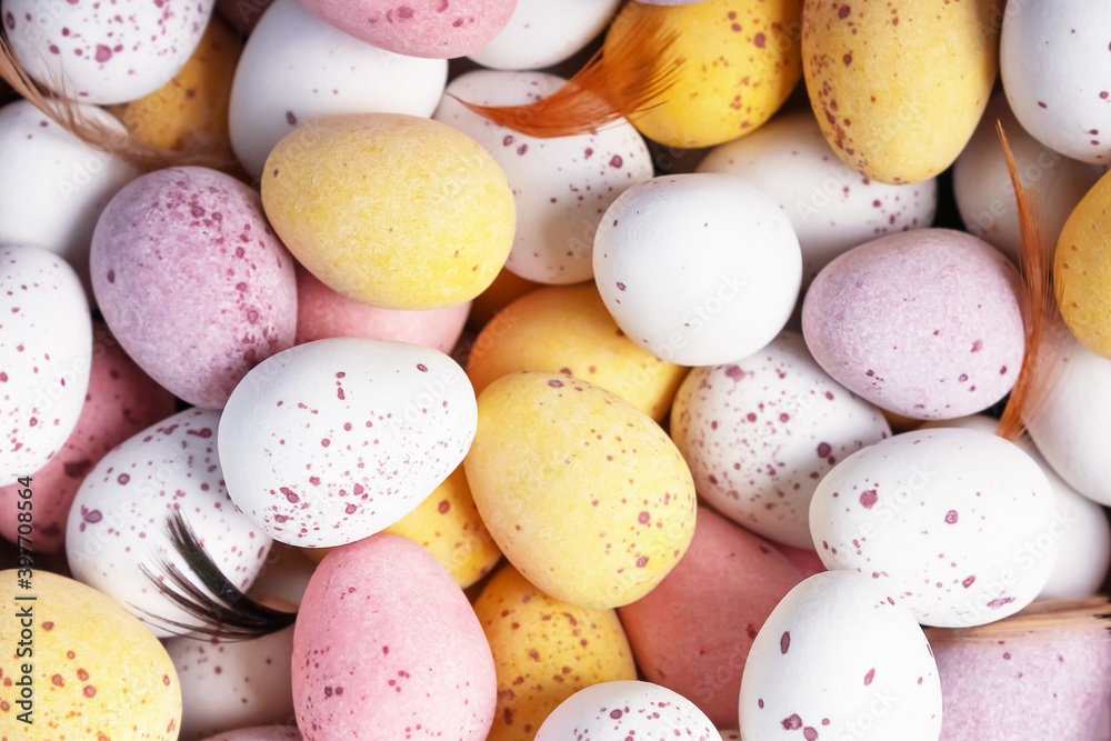Funny colourful decorative chocolate Easter eggs background. Close-up. Top view. White yellow pink eggs for Easter treat. Funny colourful decorative chocolate Easter eggs background. Close-up. Top view. White yellow pink eggs for Easter treat.