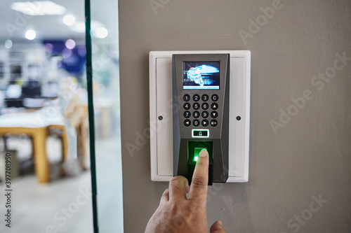 Yong man press down the finger on fingerprints scan machine to access the door security systems. Selective focused