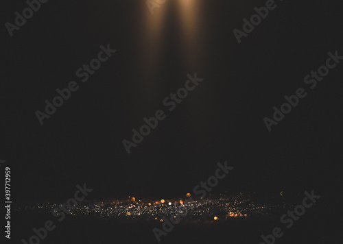 Black background with spotlight to Luxurious gold glitter sparkling background © escapejaja