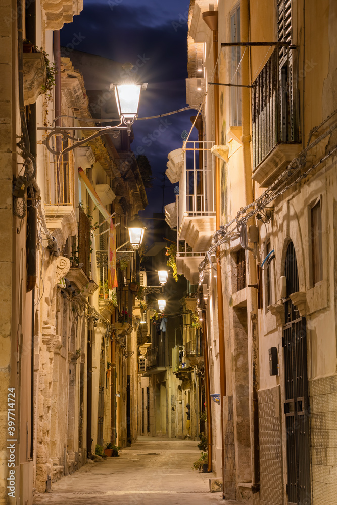 Narrow street in Ortygia, the historical part of Syracuse at night, Sicily