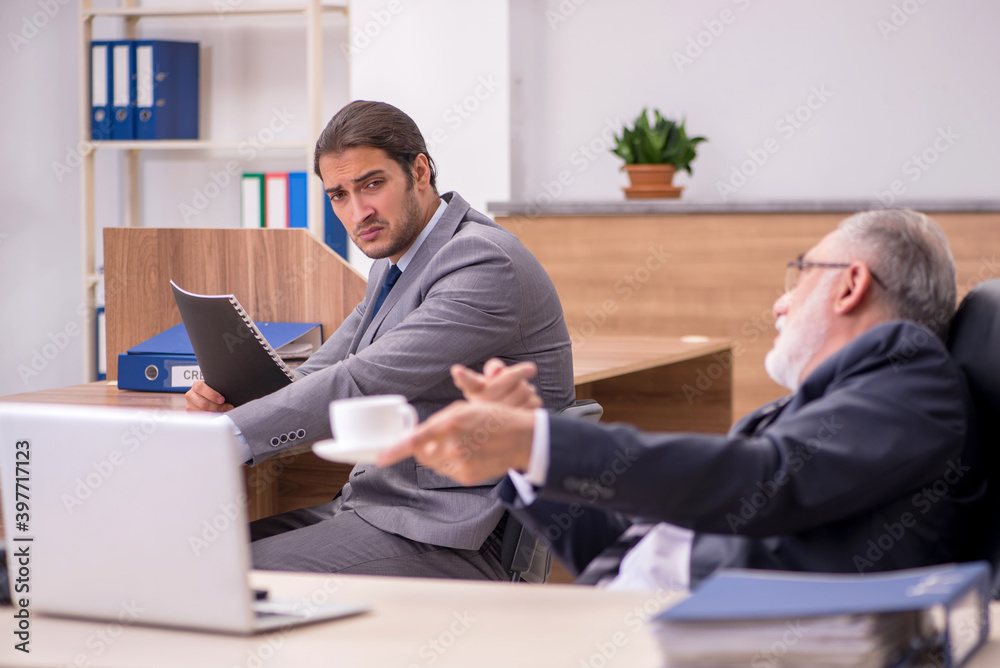 Old boss and young male assistant in the office Old boss and young male assistant in the office