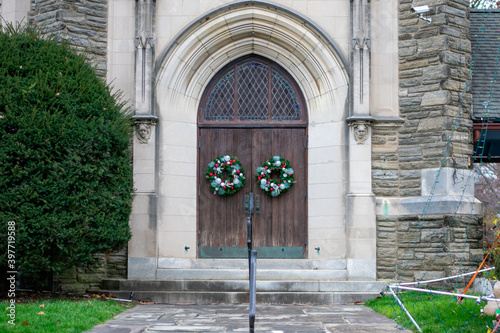 A Wooden Door With Christmas Wreaths on Them