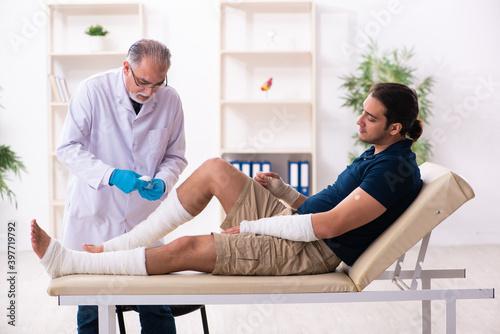 Young injured man visiting old doctor traumatologist © Elnur
