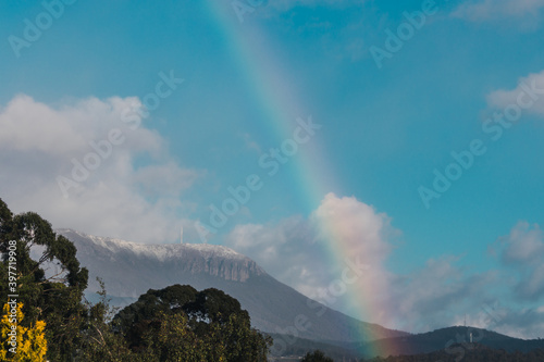 Tasmanian landscape with green hills and mountains with rainbow