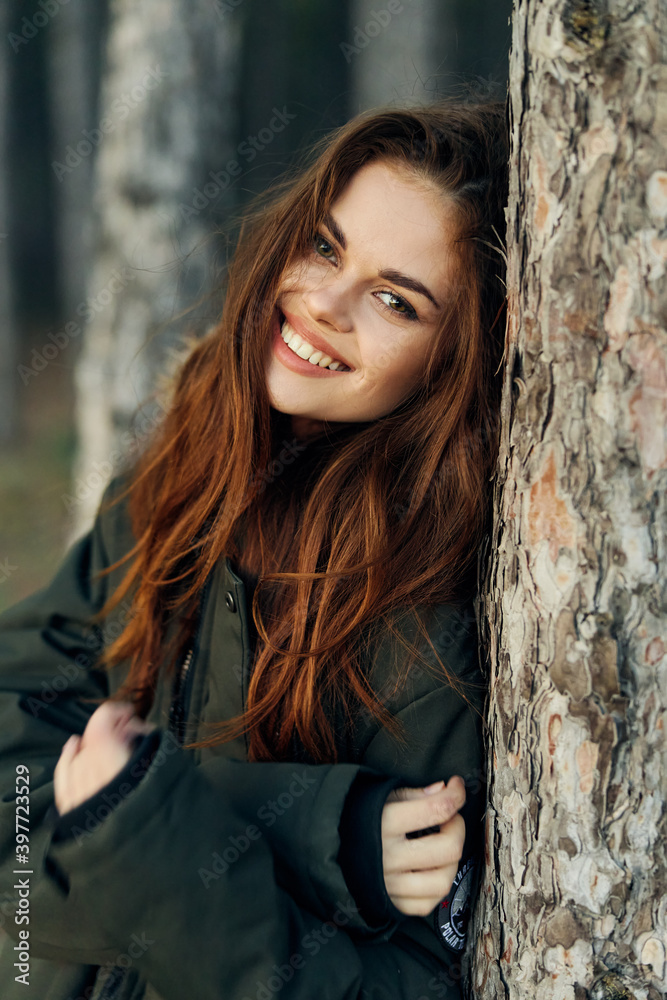 Fototapeta premium Smiling woman in warm jacket in the forest vacation lifestyle
