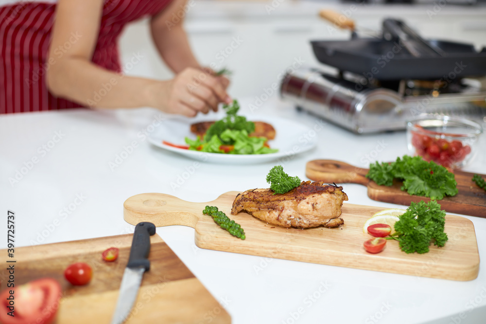 Asian woman making a steak in the kitchen. Asian woman making a steak in the kitchen.