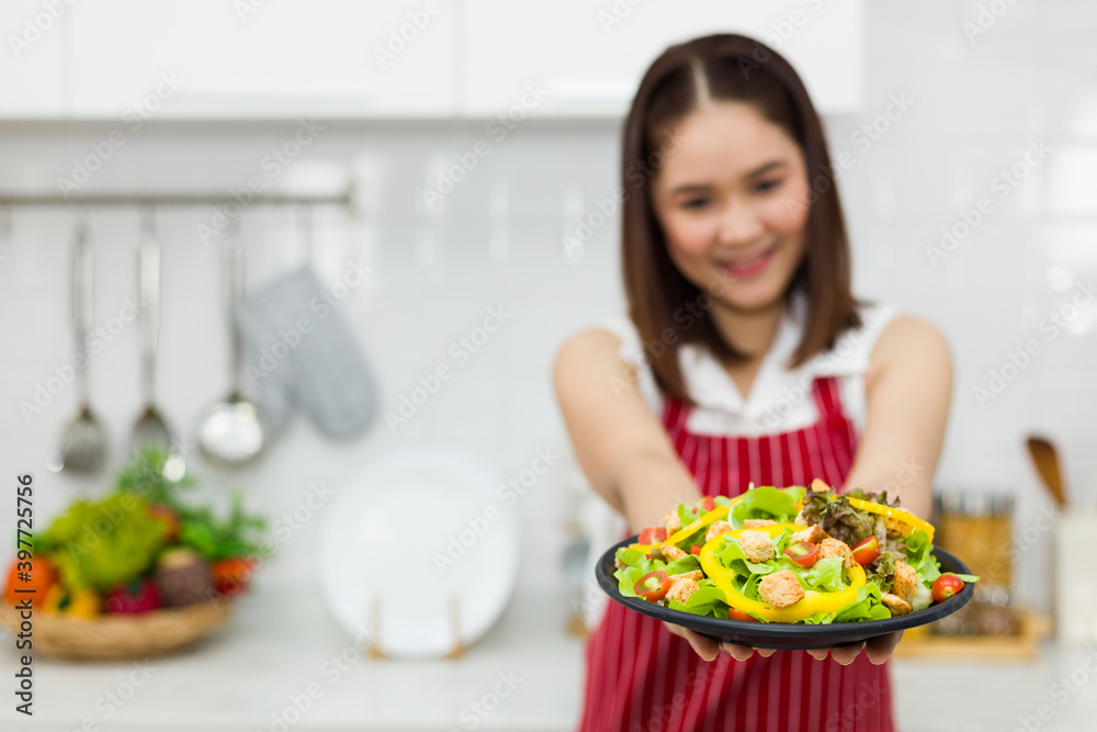 Asian housewife holding an organic salad plate Asian housewife holding an organic salad plate
