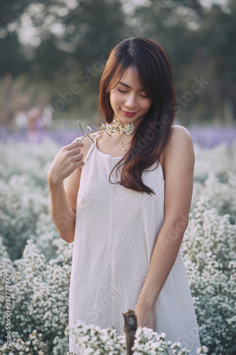 Obraz na płótnie Shy Asian woman in white dress walking in the garden of white flowers w salonie
